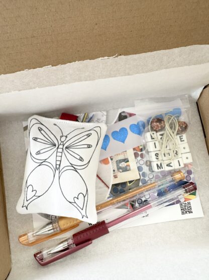 kit pour fabriquer son cadeau Merci maîtresse merci maître ou ATSEM avec un porte-clés papillon en tissu à colorier, des stylos gel et des perles lettre alphabet imaginé par Anne Da Cunha-Guillegault en exclusivité pour la marque An'imato