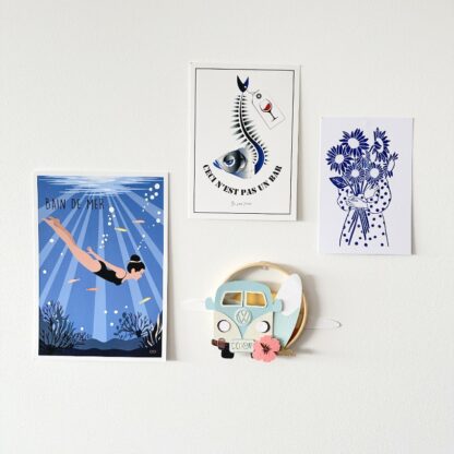 déco de mur avec un cercle décoratif avec une combi une planche de surf, une fleur hibiscus devant un couché de soleil nuageux réalisé en papiers découpés Design Anne Da Cunha Guillegault en exclusivité pour la marque An'imato
