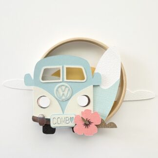 cercle décoratif avec une combi une planche de surf, une fleur hibiscus devant un couché de soleil nuageux réalisé en papiers découpés Design Anne Da Cunha Guillegault en exclusivité pour la marque An'imato