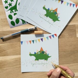 Pochette 5 invitations anniversaire thème dinosaure avec ballons gommettes, stylo gel et colles à paillette carte et gommettes imaginées par Anne Da Cunha-Guillegault en exclusivité pour la marque An'imato