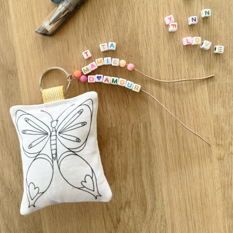 Kit cadeau femme fille tata mamie maman avec porte-clés ou accroche porte en tissu à colorier motif papillon et perles alphabet pour écrire un message mamie tata d'amour imaginé par Anne Da Cunha-Guillegault en exclusivité pour la marque An'imato